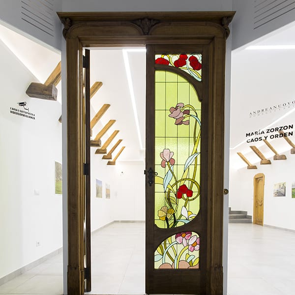 Portone in legno e vetri decorati a tema floreale dell'A.N. Gallery.