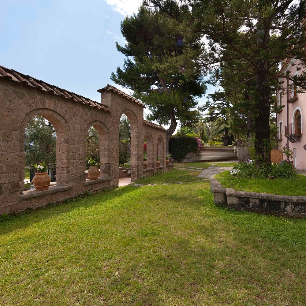 Giardino per eventi con un albero e un muro con arcate a Capo Santa Fortunata.