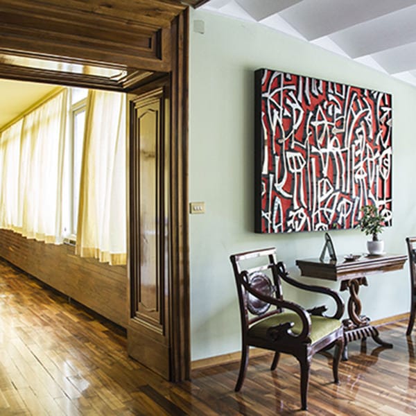 Porta aperta che dà su un corridoio con pavimento in legno del palazzo Ischitella.