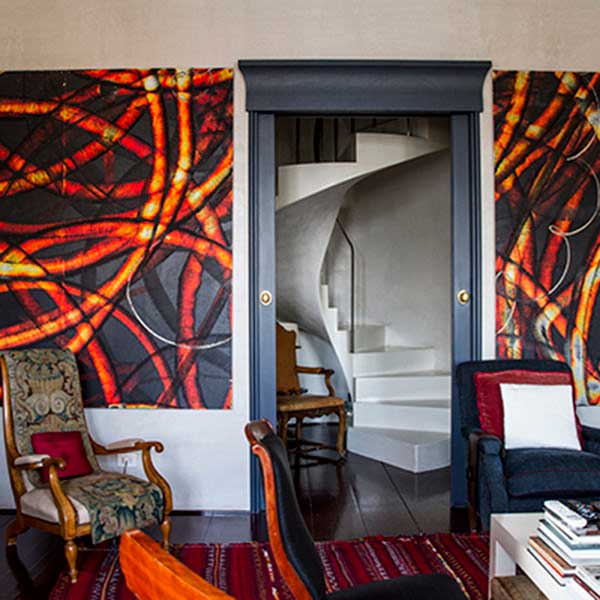 Sala de La Hermosura en paredes de colorescon con due quadri d'arte contemporanea appesi alle pareti e poltrone di vari stili.