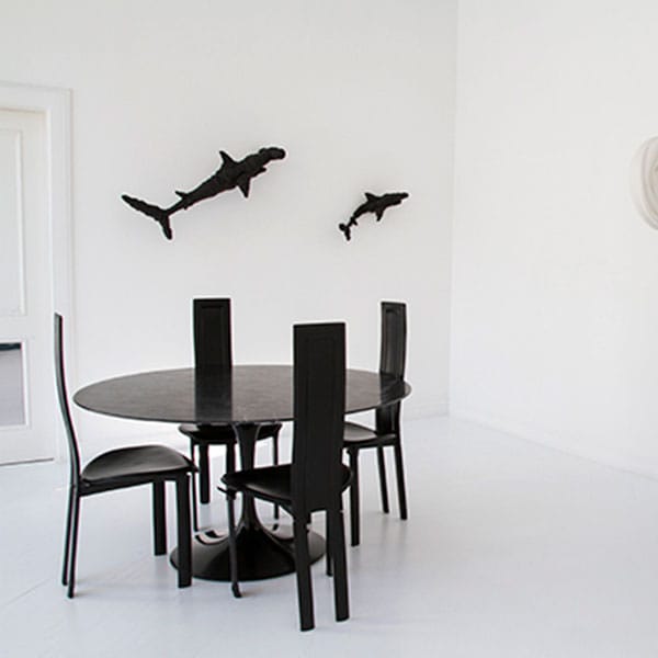 Tavolo e sedie nere in una stanza bianca utilizzabile come location per eventi a Napoli.