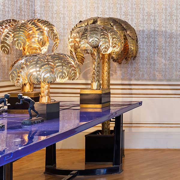 stanza della Chapeau House con tavolo viola con sopra appoggiate tre palme d'oro;