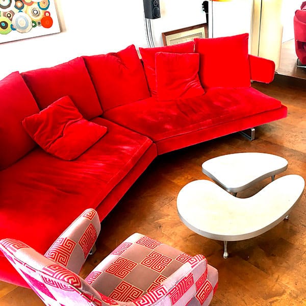 Divano rosso in un salotto con parquet in una location per eventi in Piazza Borromeo a Milano.